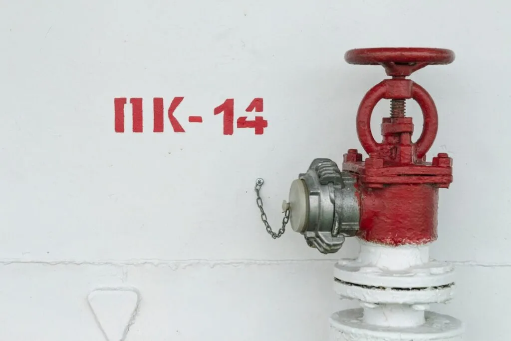 red and white fire hydrant beside white wall
